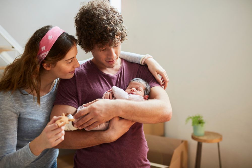 Ein junges Paar hält ein Baby im Arm.