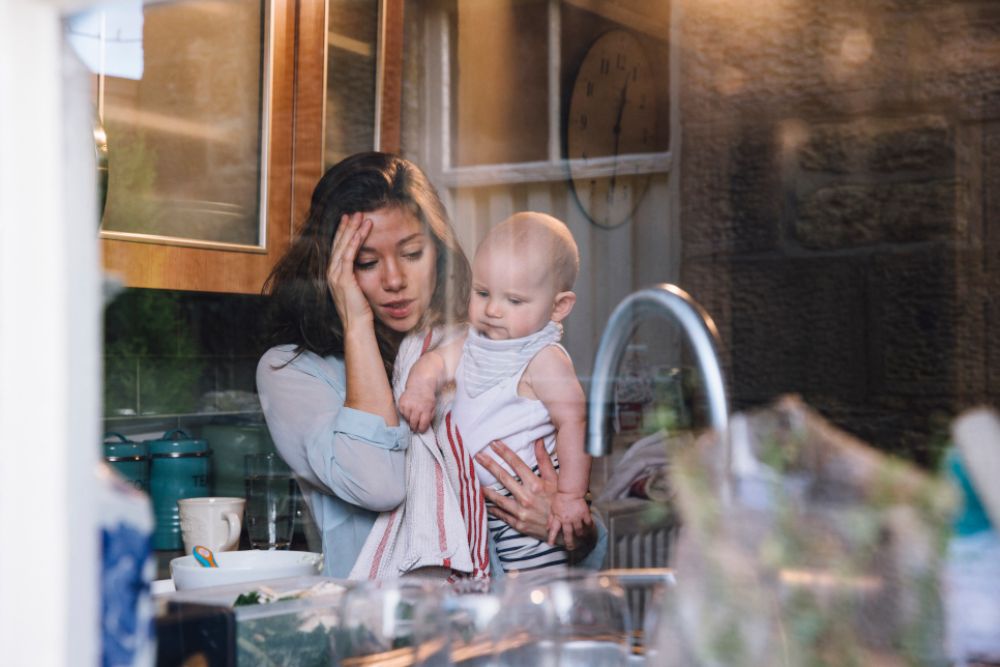 Frau in der Küche mit Kleinkind am Arm