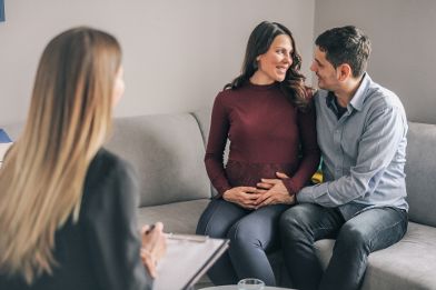 A pregnant woman and a man are attending a counselling session.